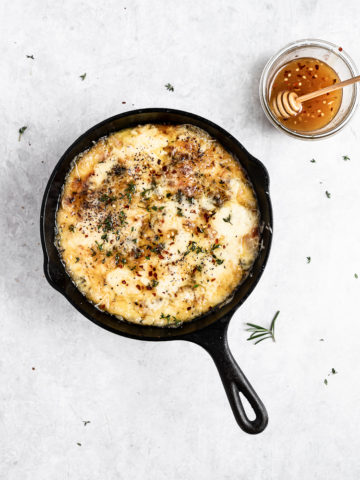 Baked Fontina with Herbs in skillet with hot honey 