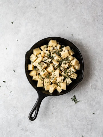 Cubed Fontina with herbs in skillet