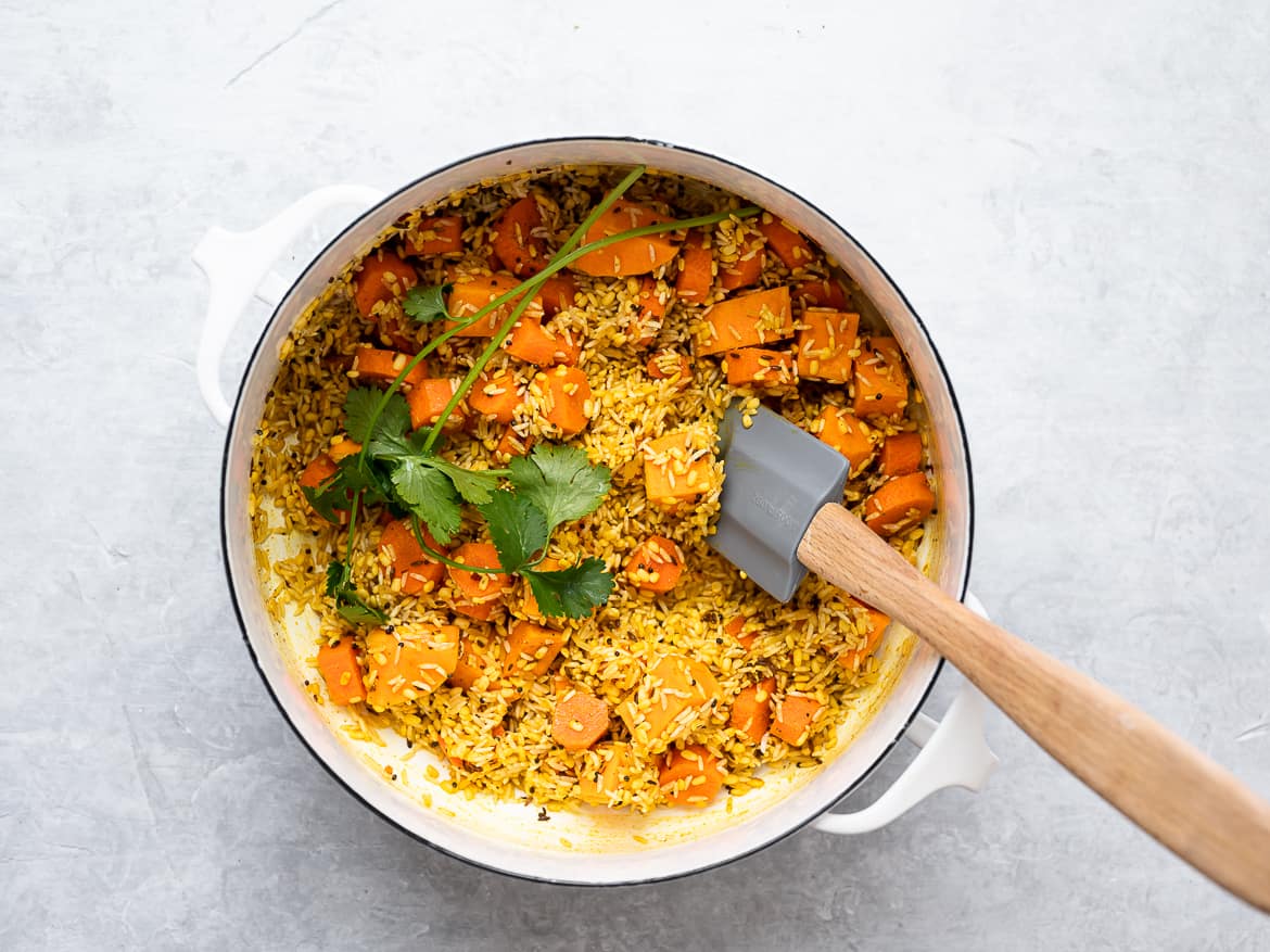 Mixing the mung dal, rice and vegetables in the pot