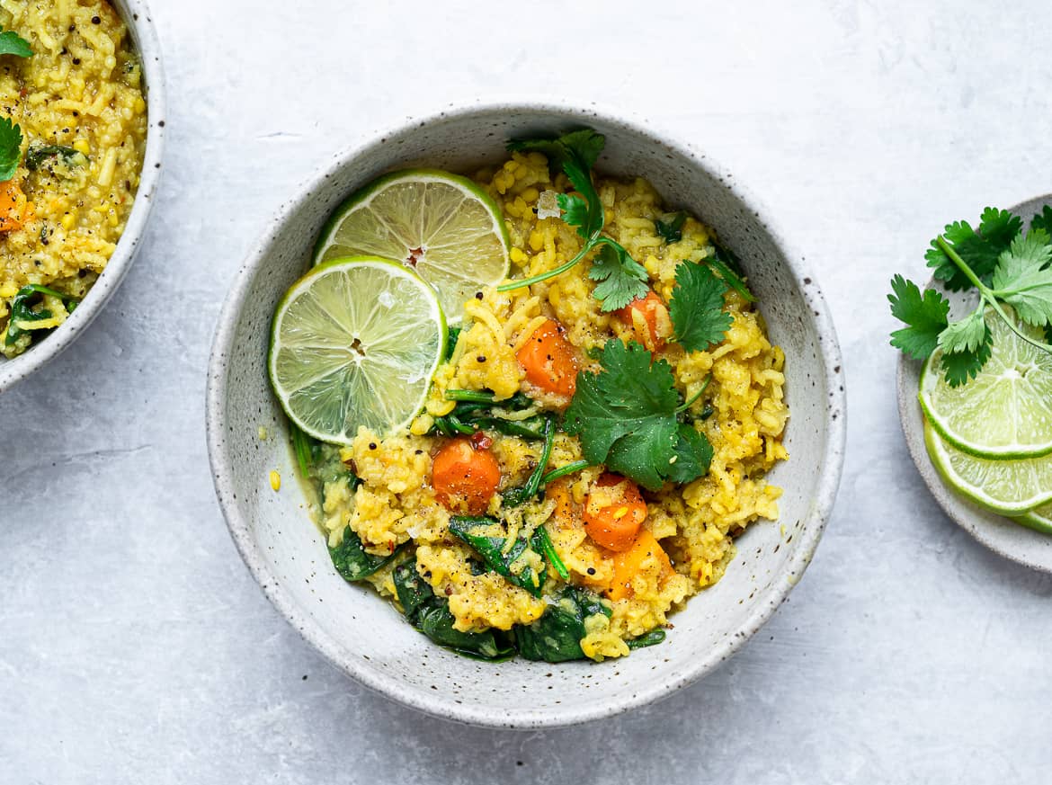 Khichdi in bowls with lime wedges