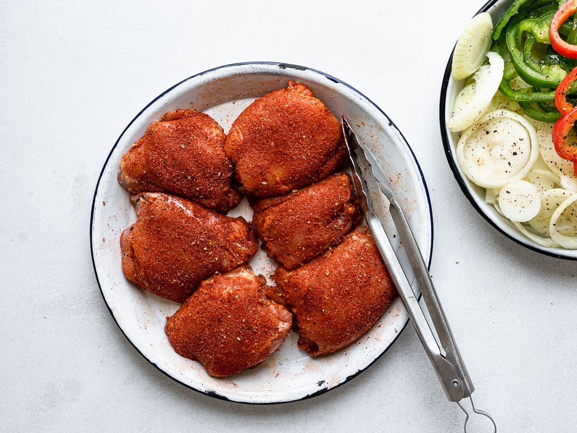 Chicken thighs on plate seasoned with spices