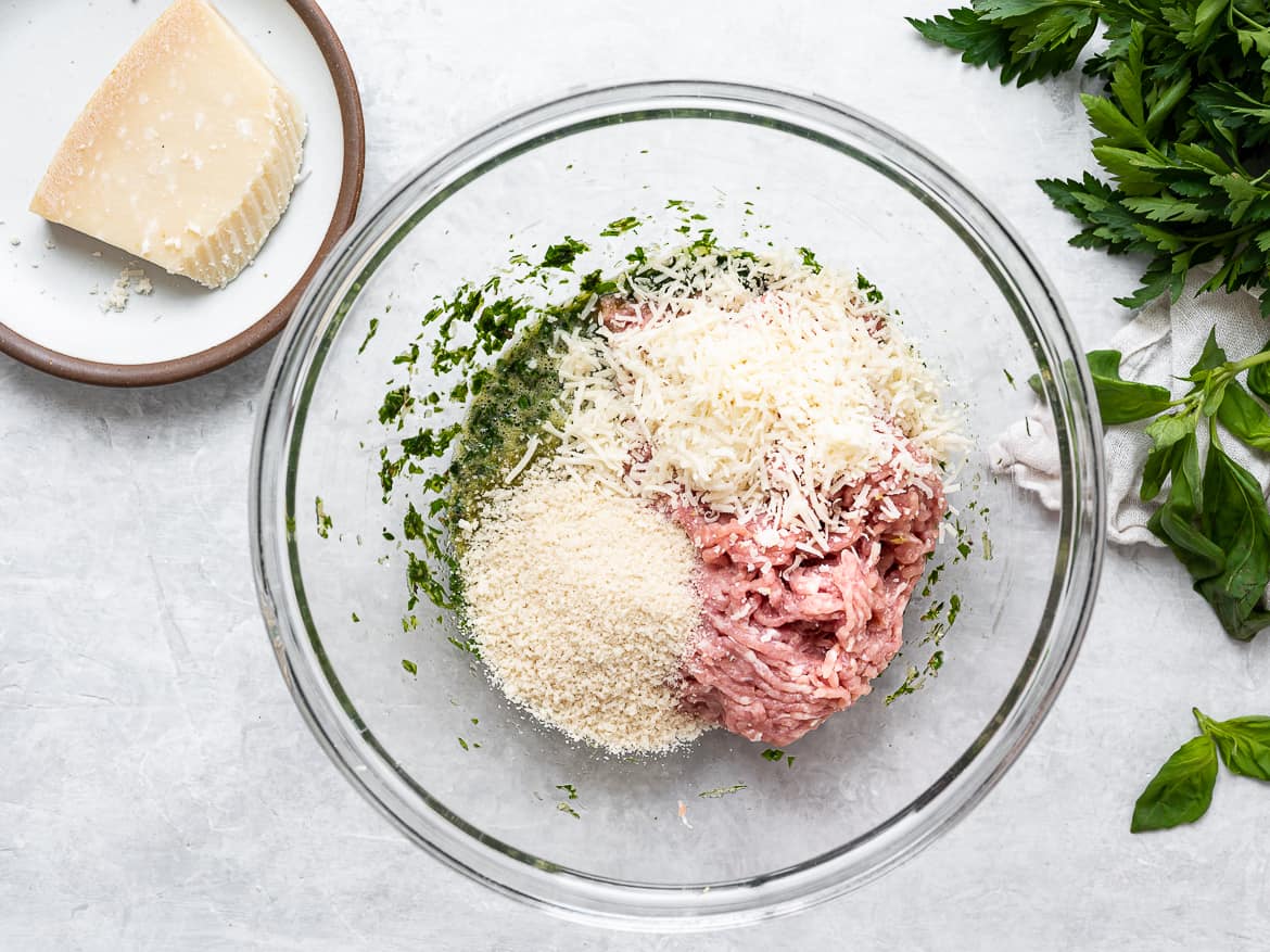 Meatball ingredients in large glass bowl.