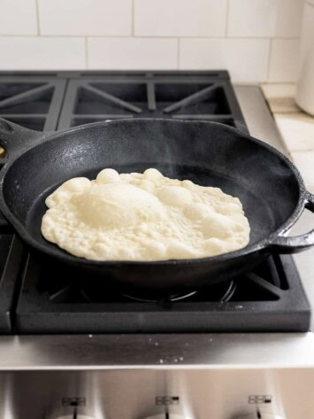 naan cooking in cast iron skillet