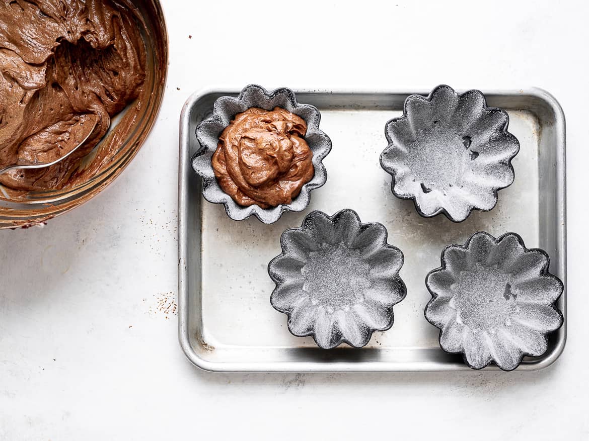 pouring chocolate batter into prepared ramekins