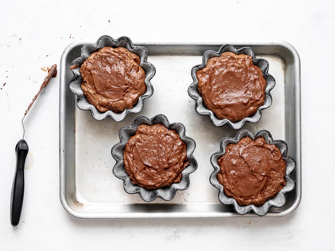 smoothing the top of the soufflés with offset spatula