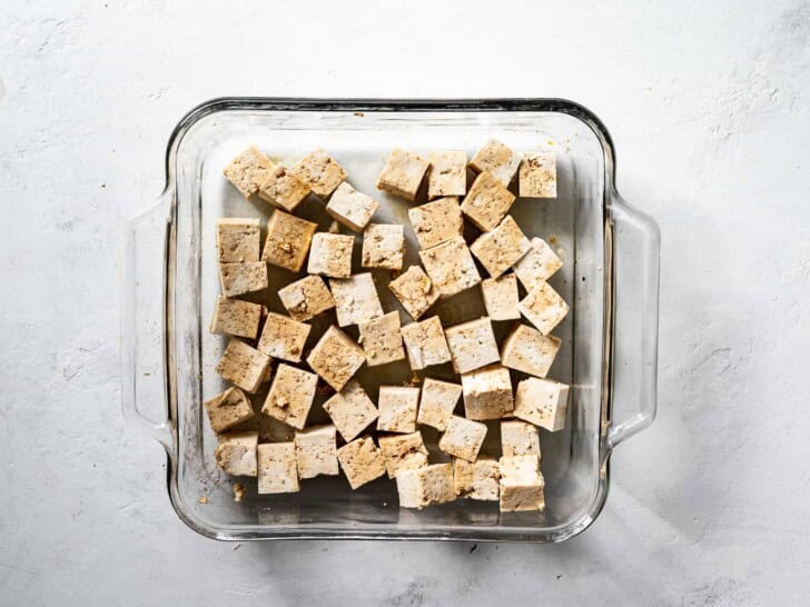 cubed tofu marinating in glass dish