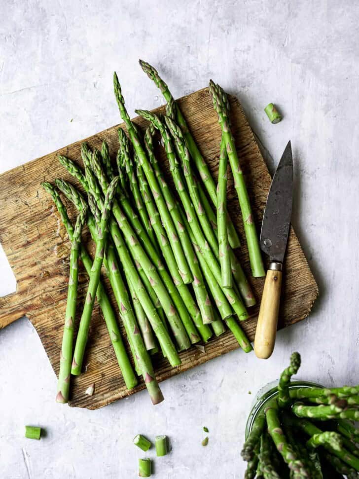 Cutting asparagus on wood board