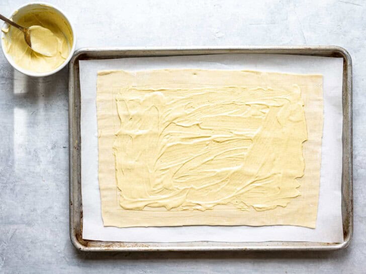 puff pastry with mustard on baking sheet