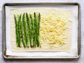 arranging asparagus on grated cheese