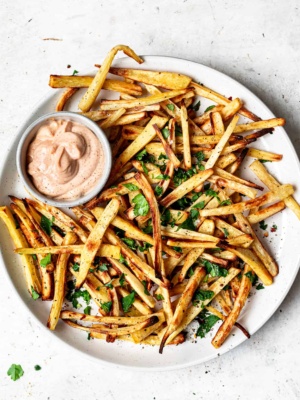 Baked parsnip fries on plate with aioli