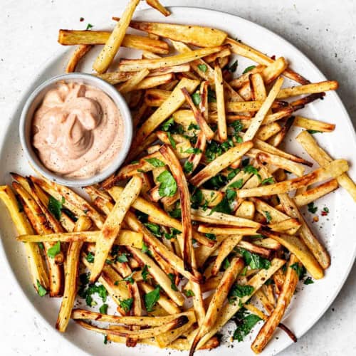 Baked parsnip fries on plate with aioli