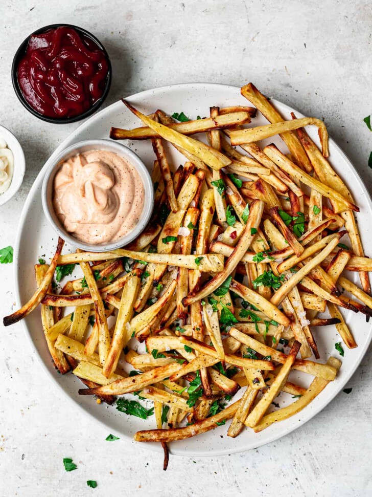 Crispy baked parsnip fries on plate with dips