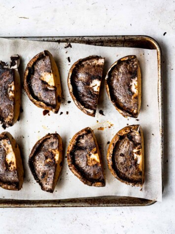 Portobello mushrooms marinating on baking sheet