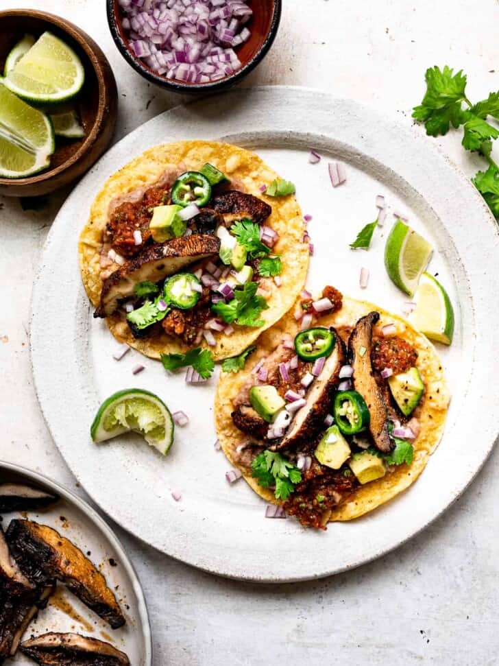 Mushroom Tostadas with refried beans and other toppings served on plate