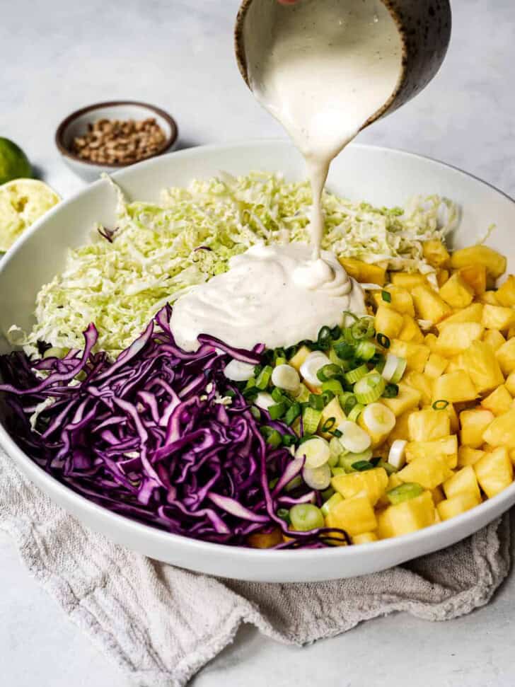 pouring dressing over slaw