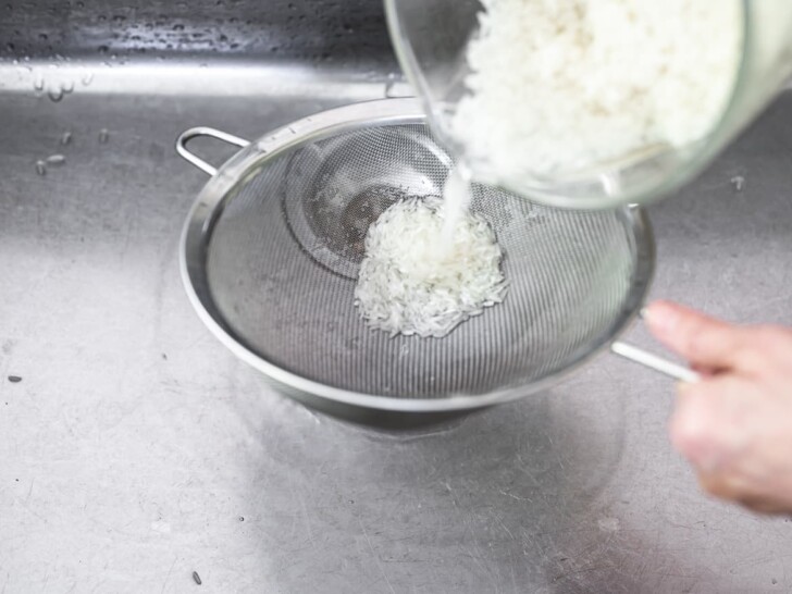 pouring rice grains into fine-mesh strainer