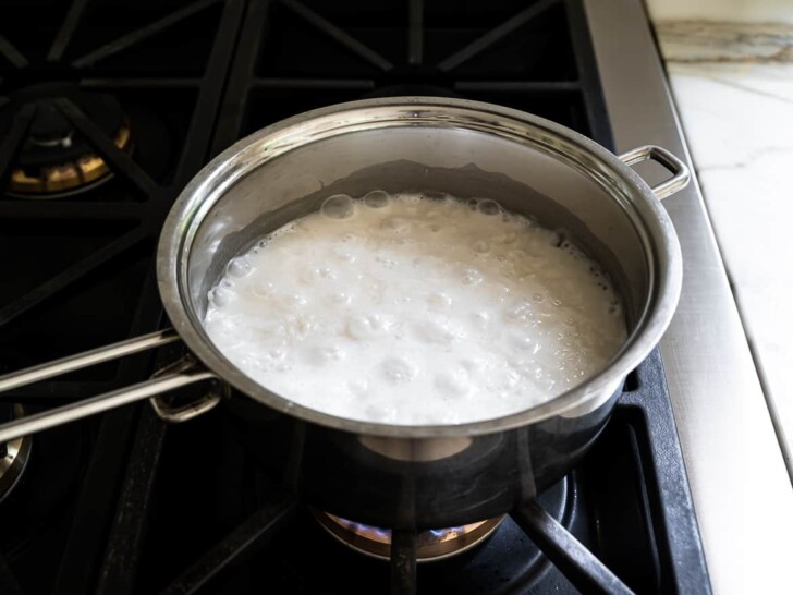Rice and liquids boiling in saucepan