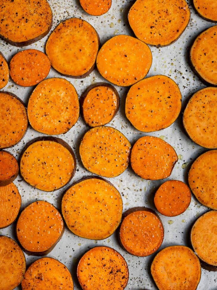 rounds of sweet potato seasoned on baking sheet