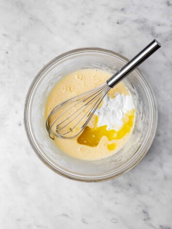 adding melted butter and yogurt to bowl