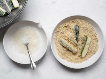 dipping zucchini sticks in Panko mixture