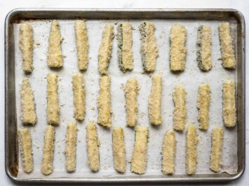 breaded zucchini sticks on baking sheet