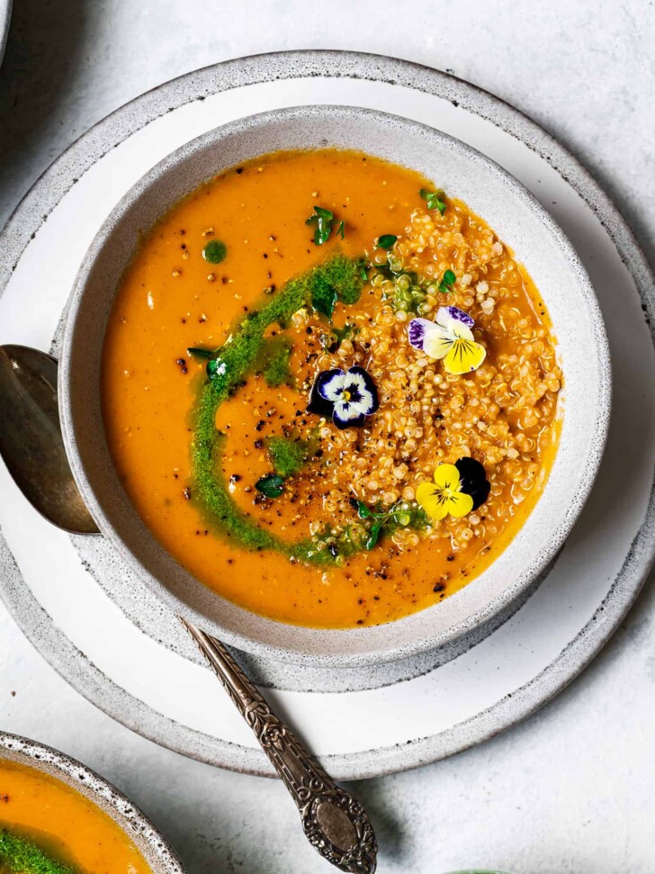 one bowl of Creamy Zucchini Tomato Soup topped with quinoa