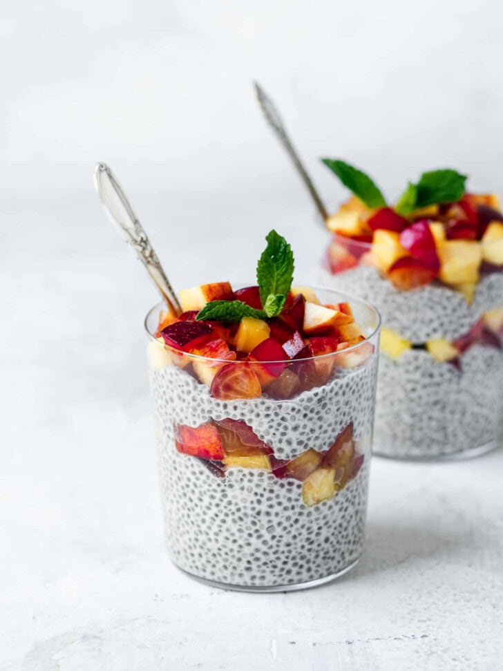 coconut chia pudding topped with fruit in glasses