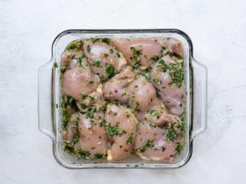 chicken marinating in glass pan