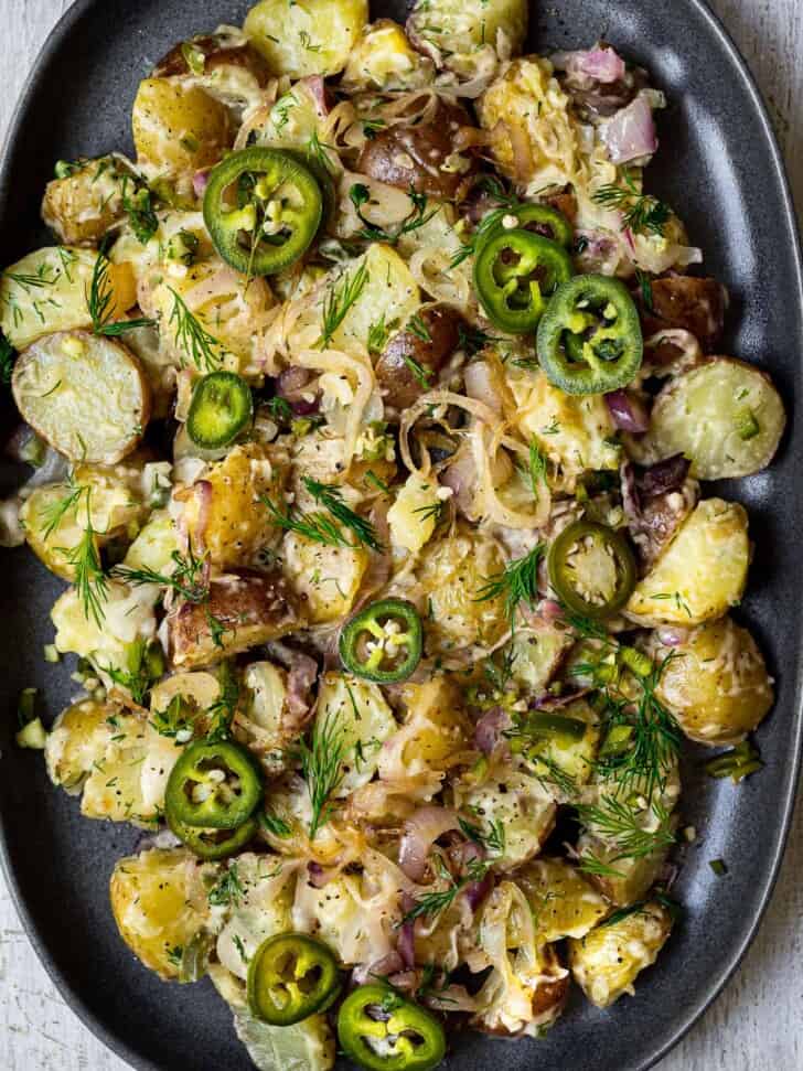 close up of potato salad with caramelized shallots on platter