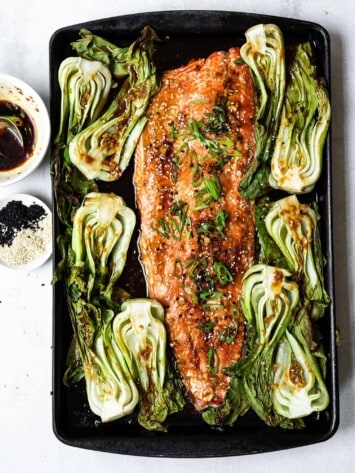 garnishing salmon with scallions and sesame seeds