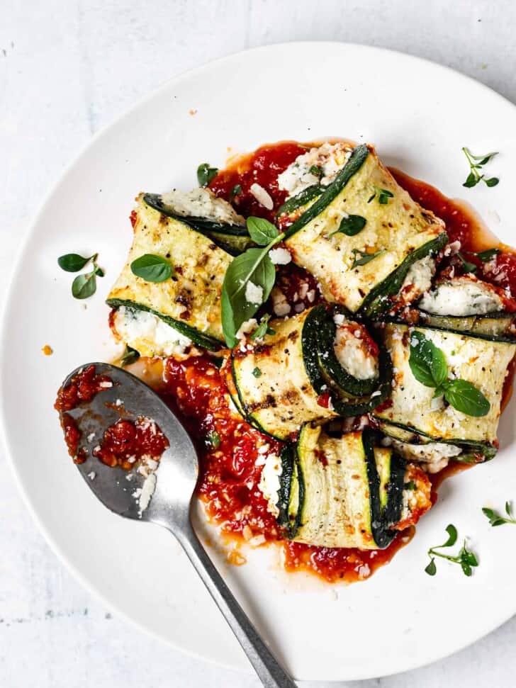 Zucchini involtini served on a plate with tomato sauce