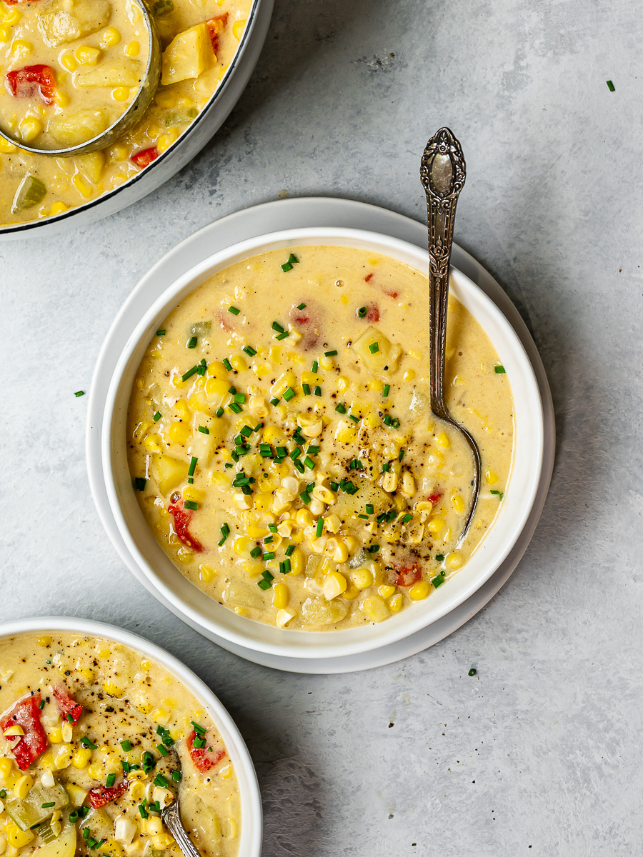 Vegan corn chowder served in two white bowls.