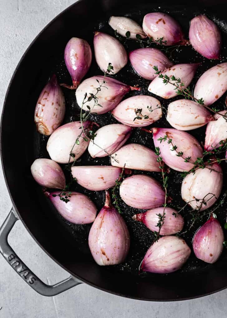 peeled shallots tossed in balsamic glaze in skillet