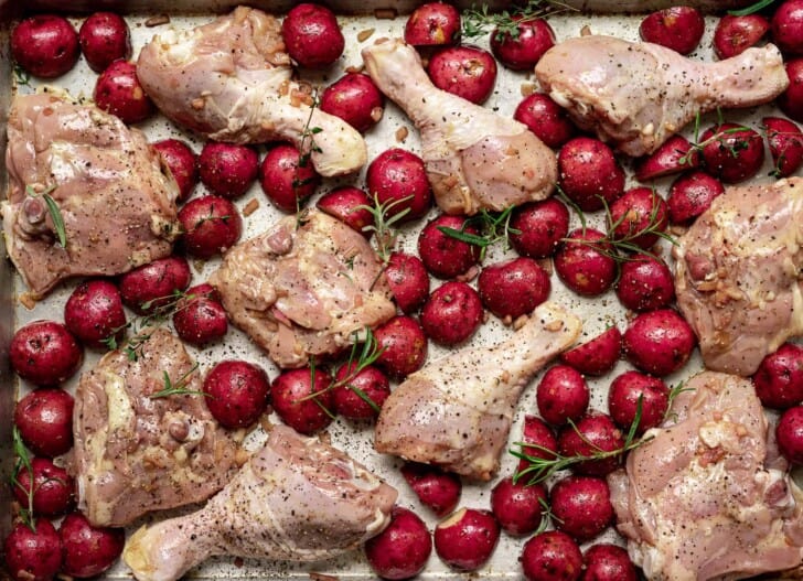 unbaked chicken and potatoes on sheet pan