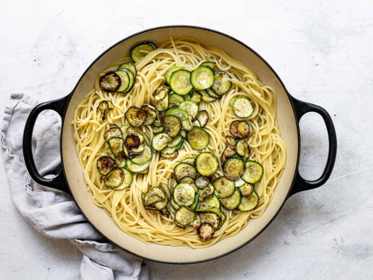 combining cooked pasta and zucchini in skillet