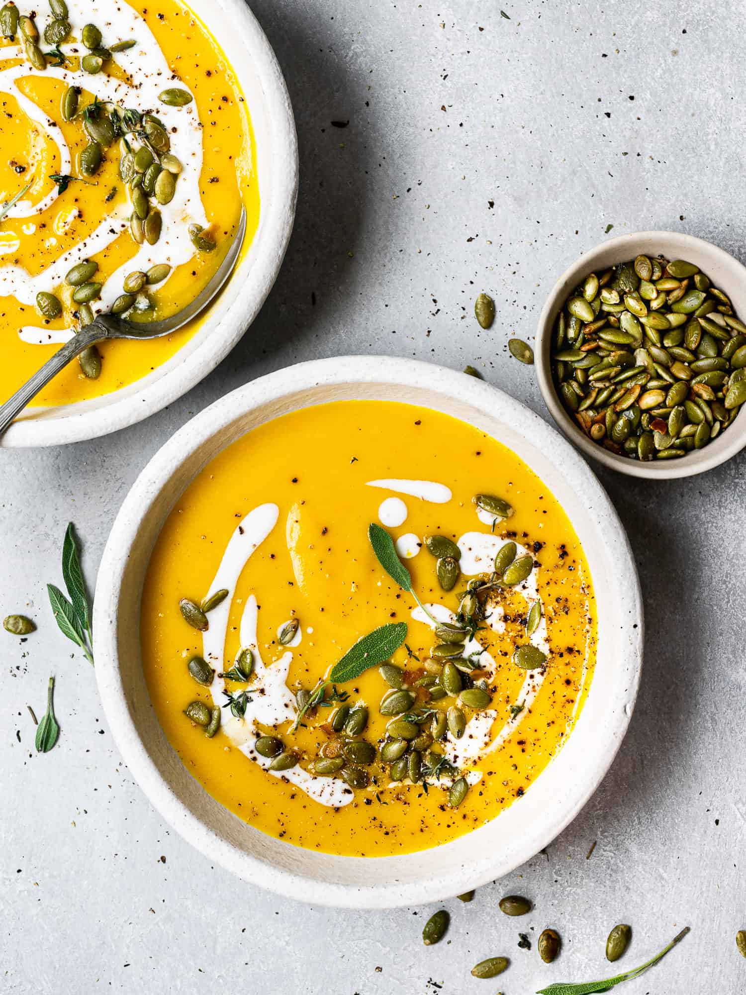 Butternut squash soup served in bowls and garnished with pepitas