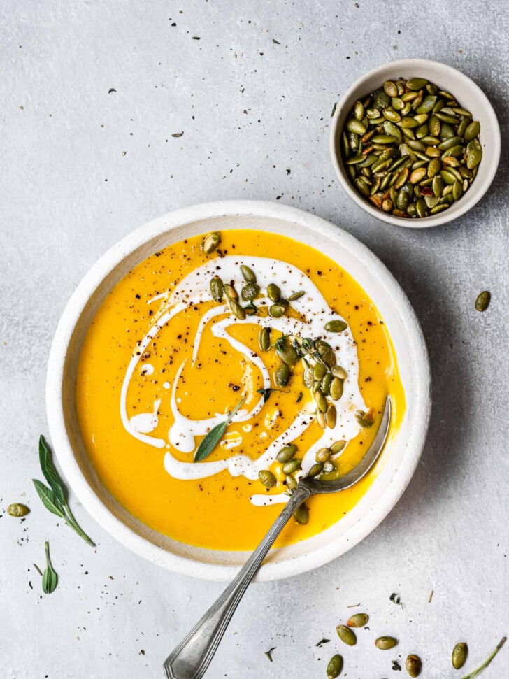Butternut squash soup served in bowl and garnished with pepitas