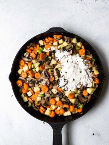 Flour sprinkled over vegetables in skillet
