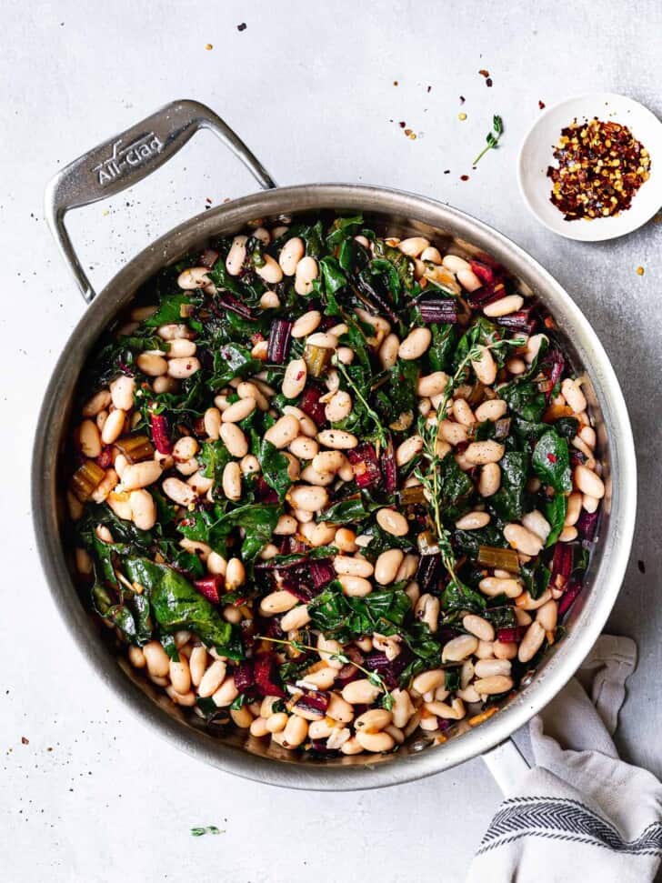 Sautéed Swiss chard with White beans in skillet 