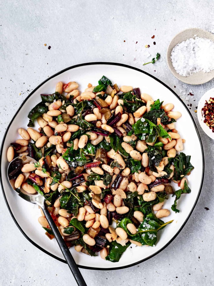 Sauteed Swiss chard with white beans served on a platter