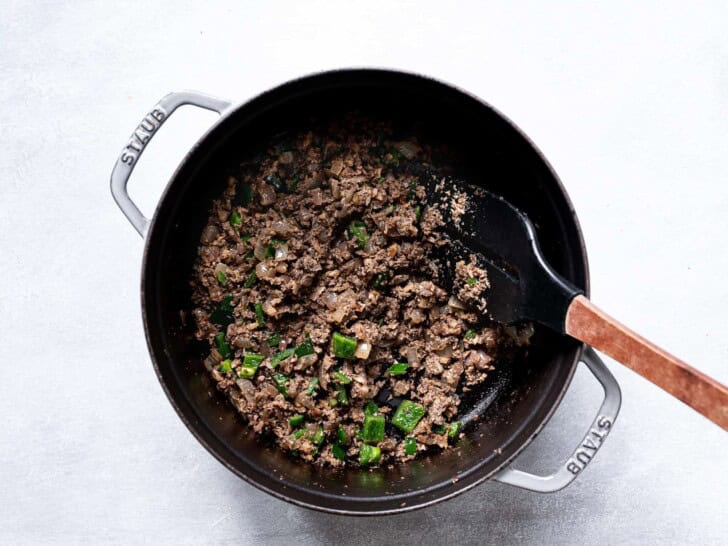 mushroom-walnut mixture in pot with green peppers