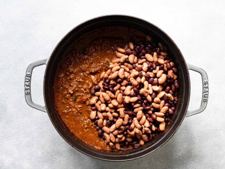 adding the beans to the chili 