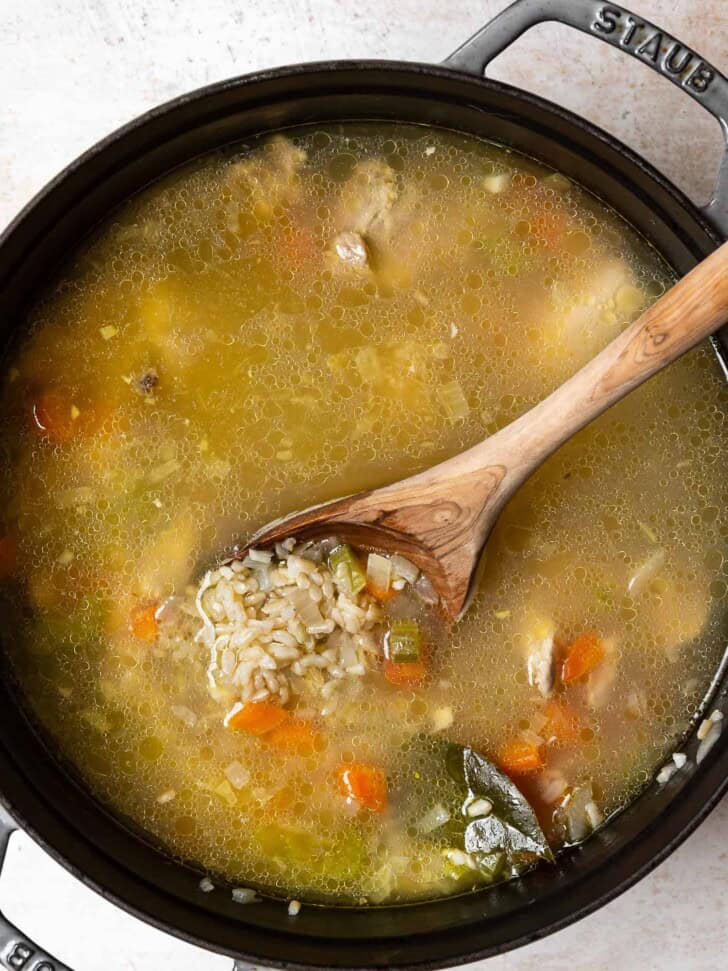 Spoon showing cooked rice in soup