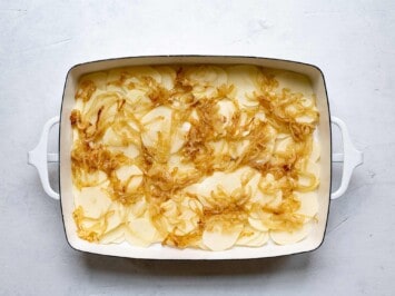 layering onions on top of potatoes slices