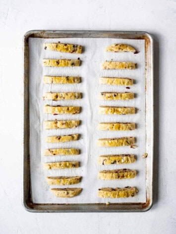 Biscotti lined up on baking sheet ready fro second bake