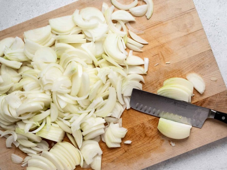 a pile of sliced onions on cutting board