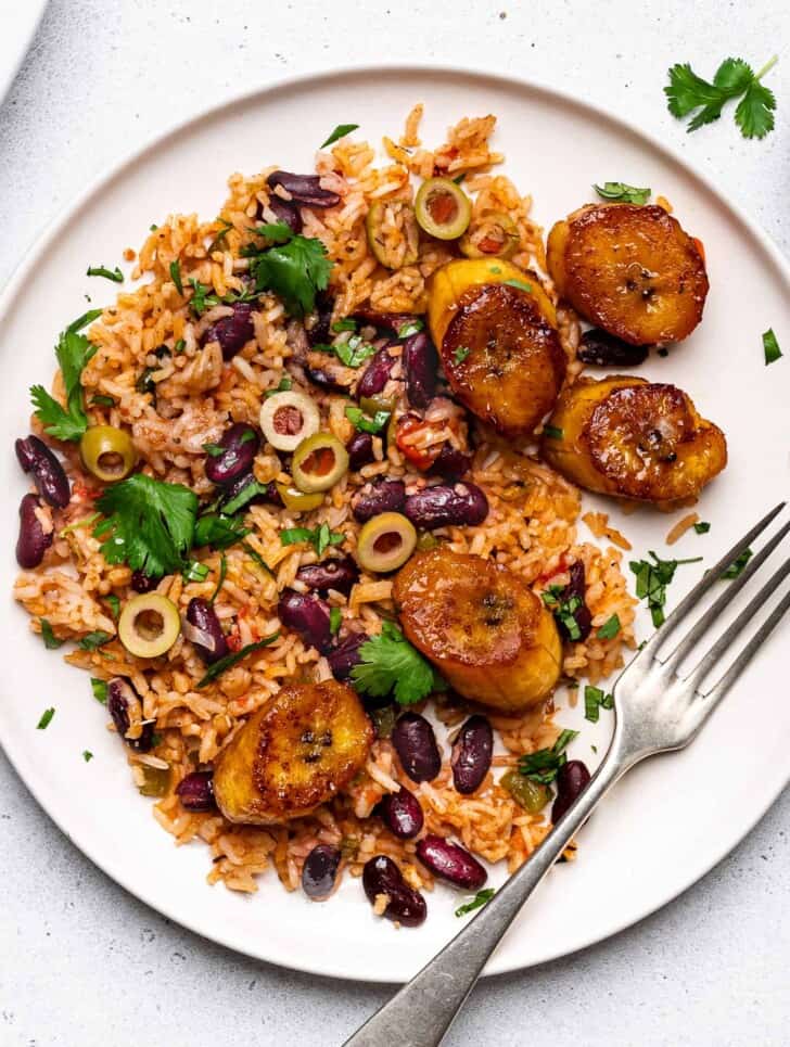 close-up of one-pot rice and beans served on plate with plantains