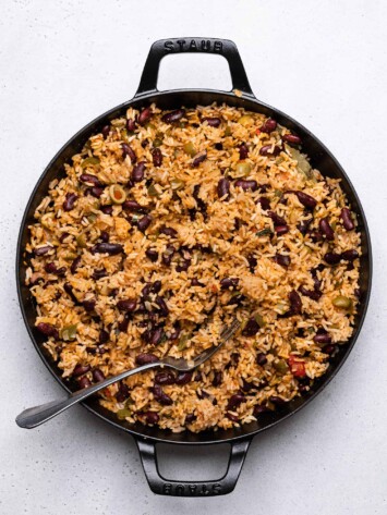 rice and beans fluffed with fork in skillet