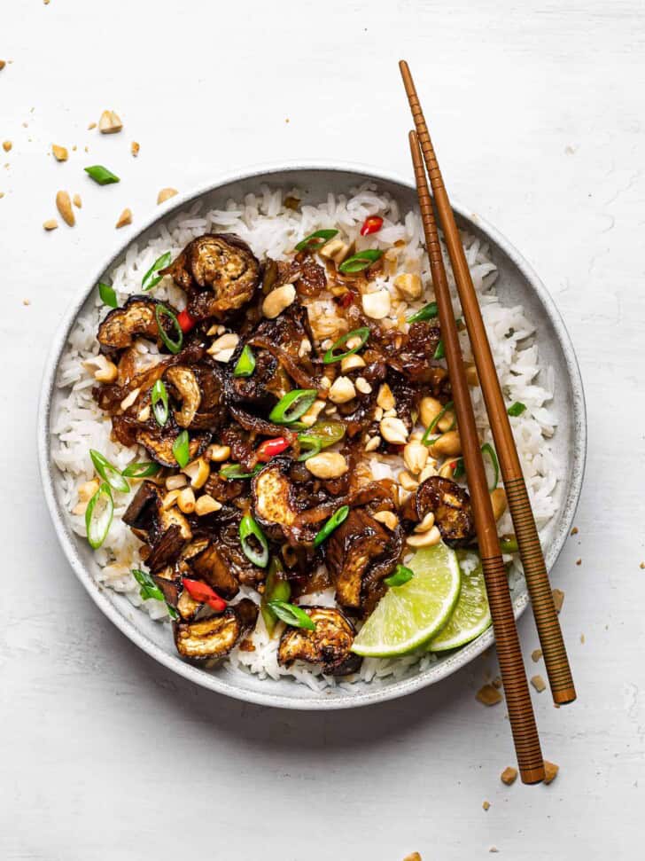 Chinese eggplant stir-fry served over coconut rice with chop sticks