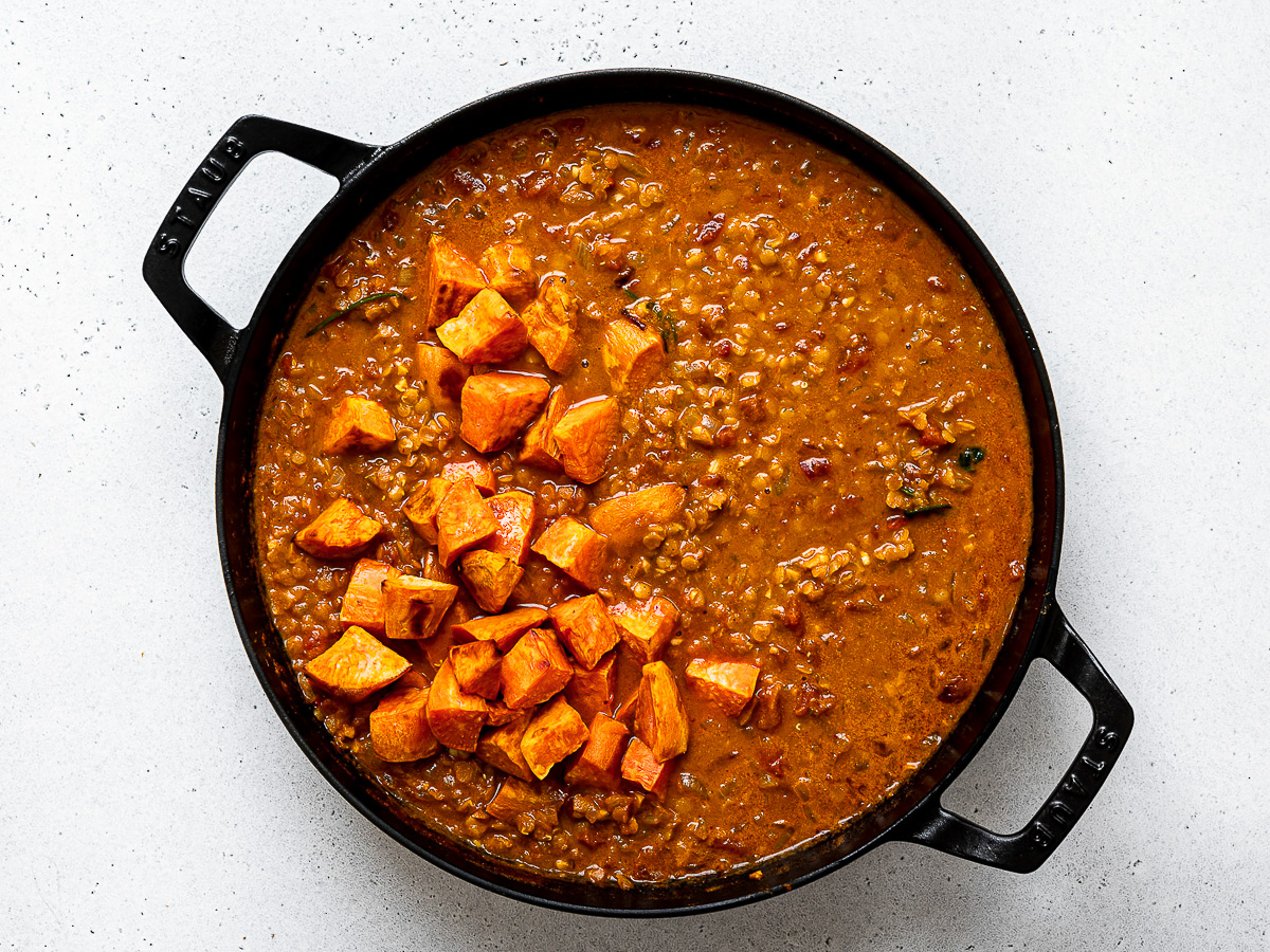 Adding roasted sweet potatoes to soup.